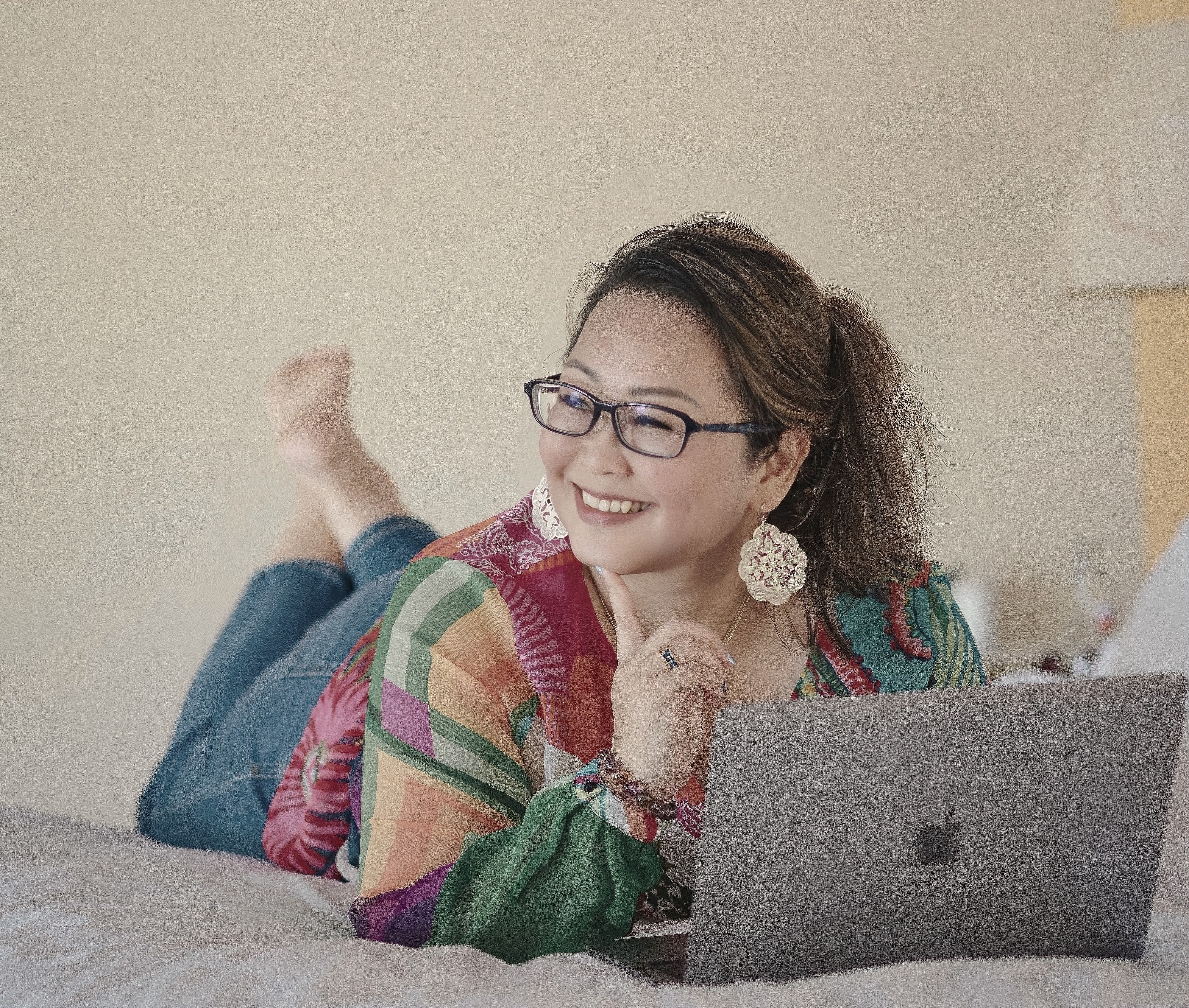 Patsy Woo working on laptop from bed